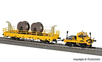 Ciągnik kołowo-szynowy z platformą niskoburtową Unimog z ładunkiem szpul kabli